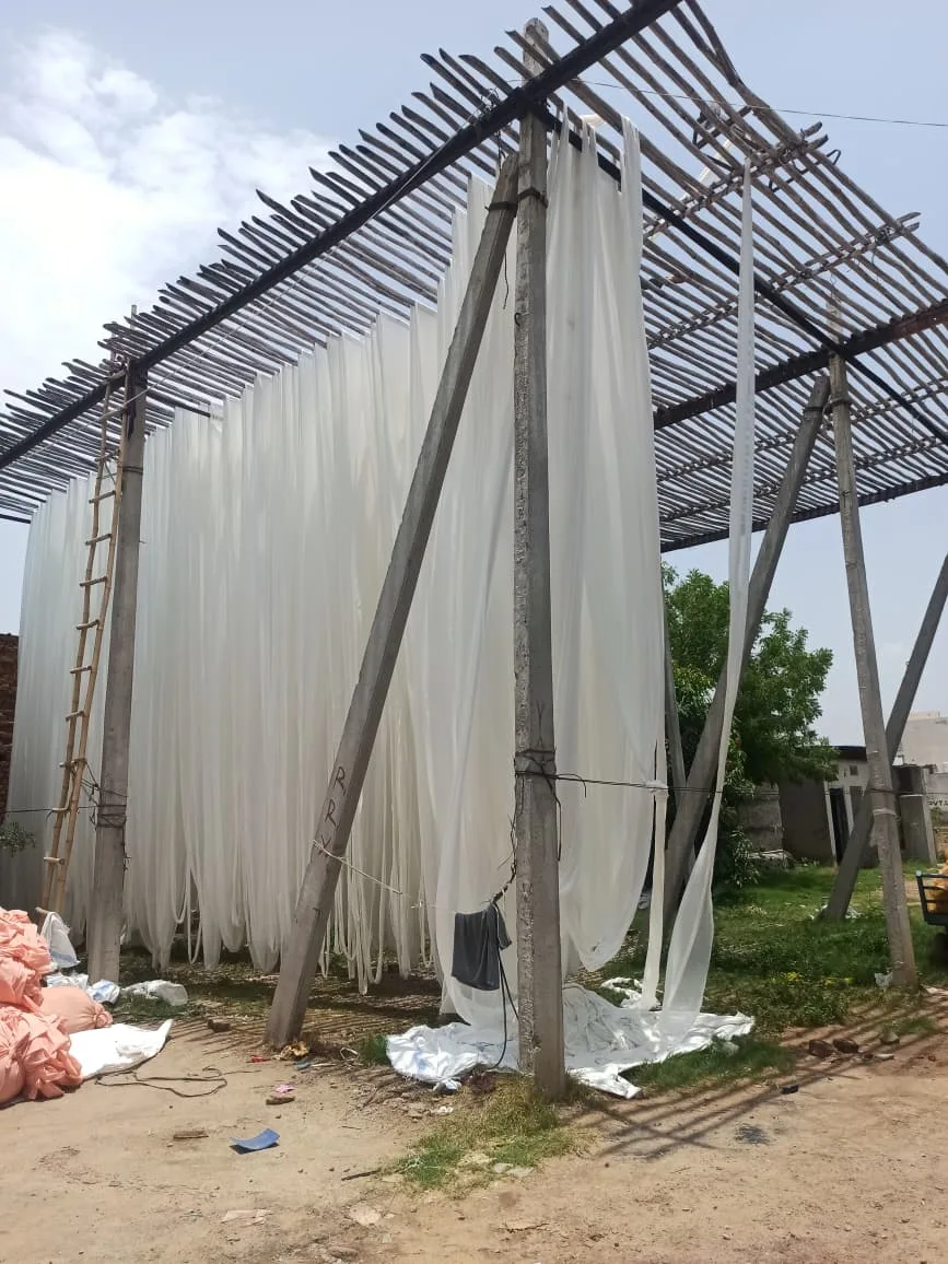 White fabric rolls drying outdoors under the sun
